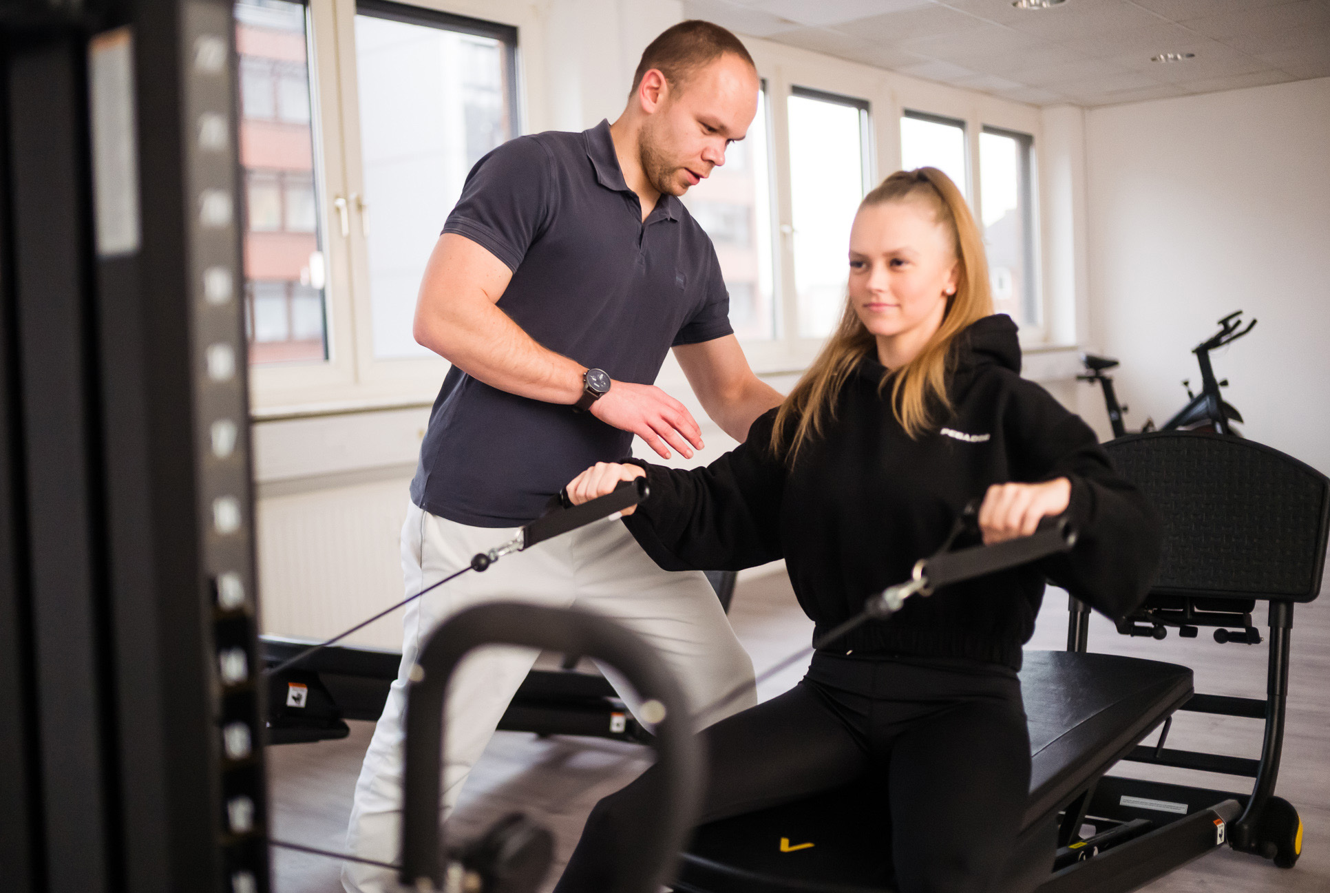 physiotherapeut mit patientin am geraet